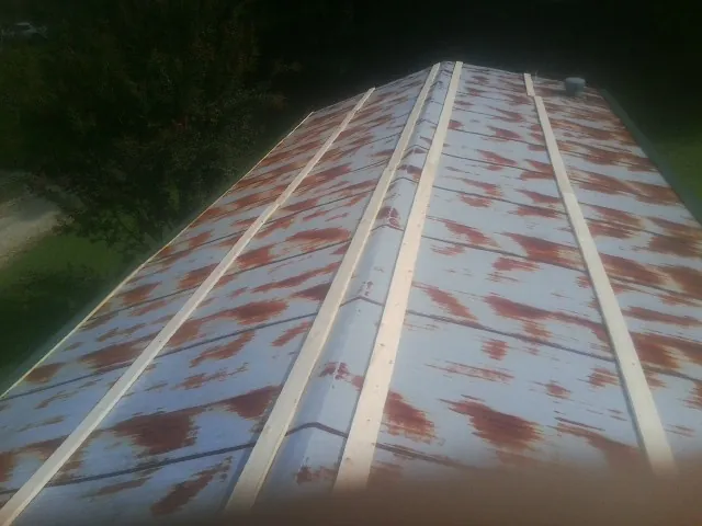 Rusted metal roof panels with new wood purlins before replacement — Storm Damage Roof Repair in Crimora by Roofing Brothers