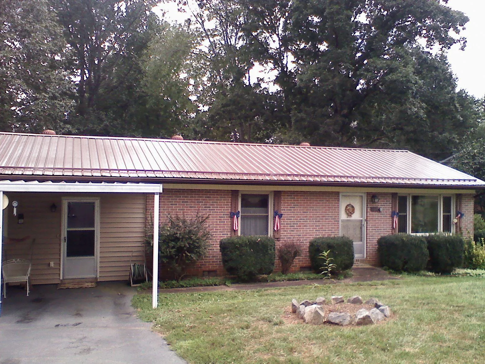 Bronze metal roof and carport on a brick ranch home — Roof Repair work by our crew in Crimora
