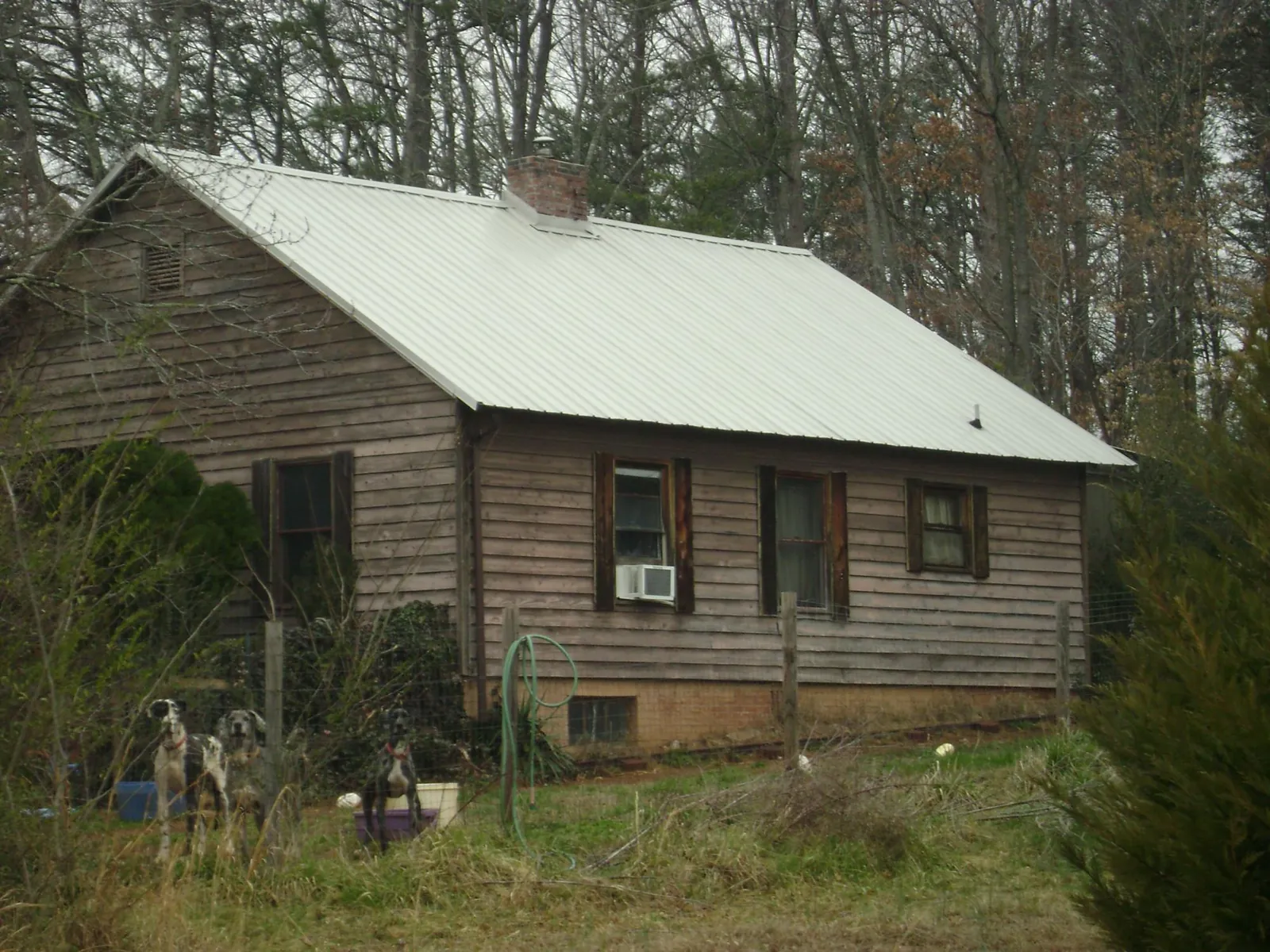 White metal roof on an old wood sided farmhouse, from a Metal Roof Installation job in Crimora